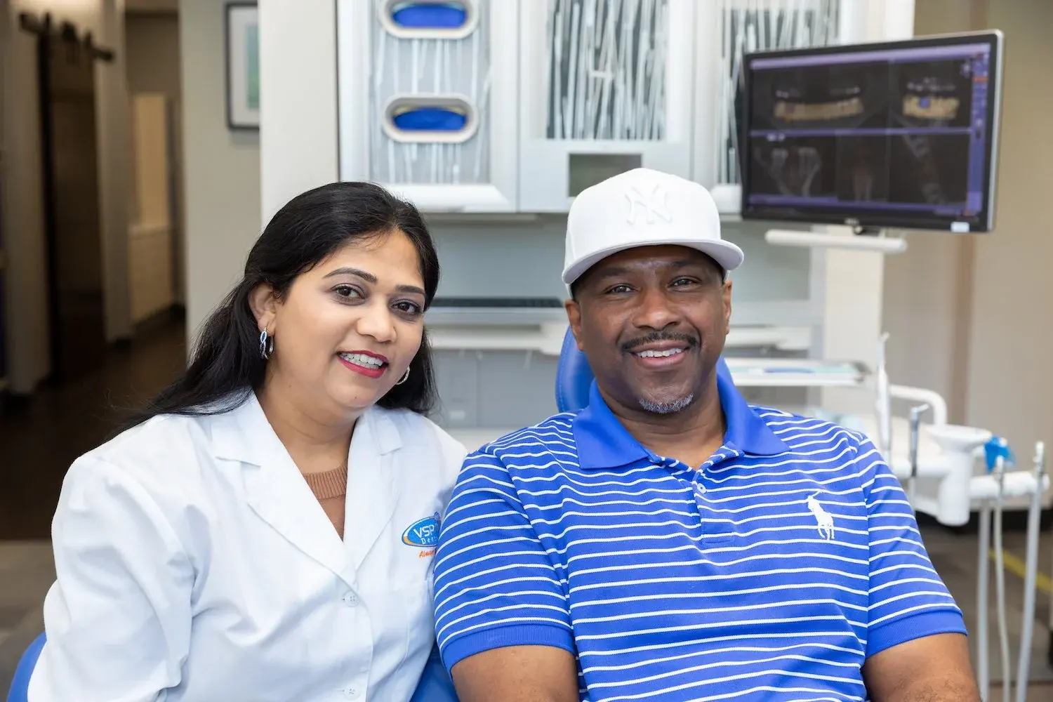 VSP Dental clinician smiling beside a patient in a treatment room
