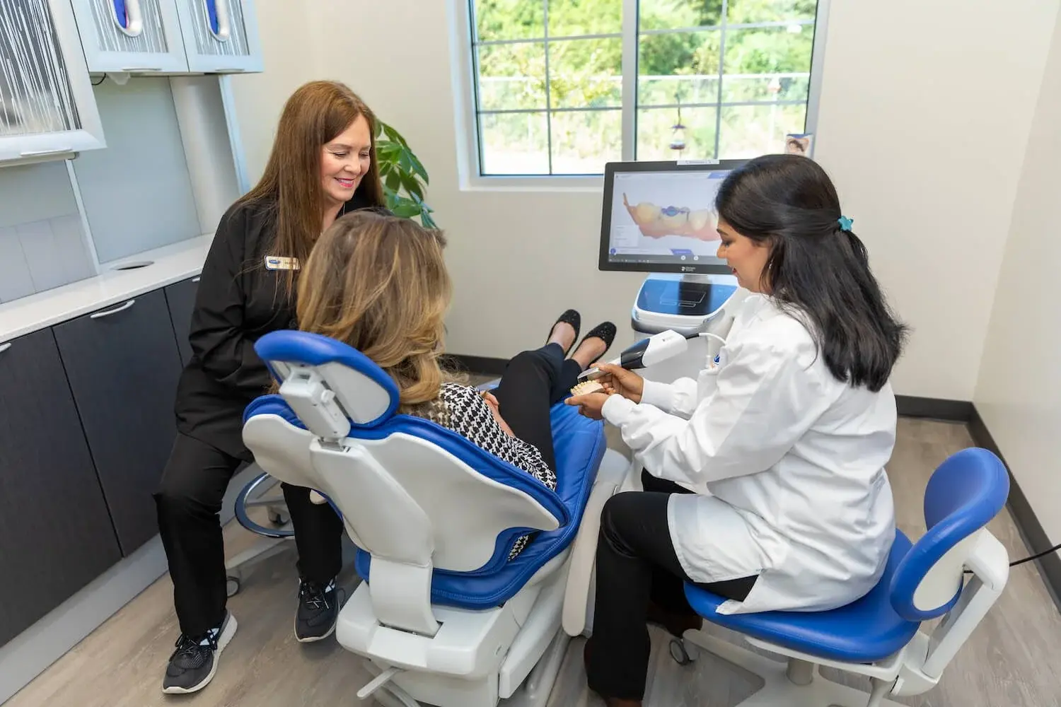 VSP Dental clinician and assistant speaking with a patient during a comfortable treatment-room visit